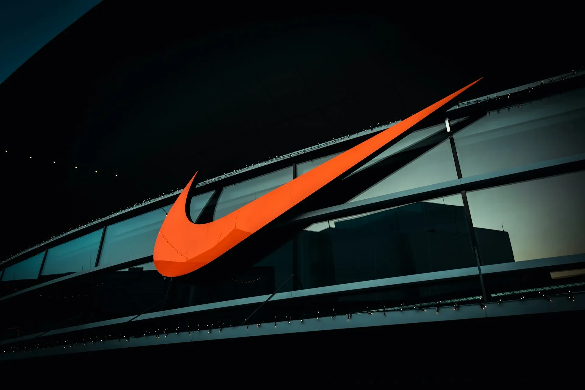 Orange Nike brand logo on a glass building