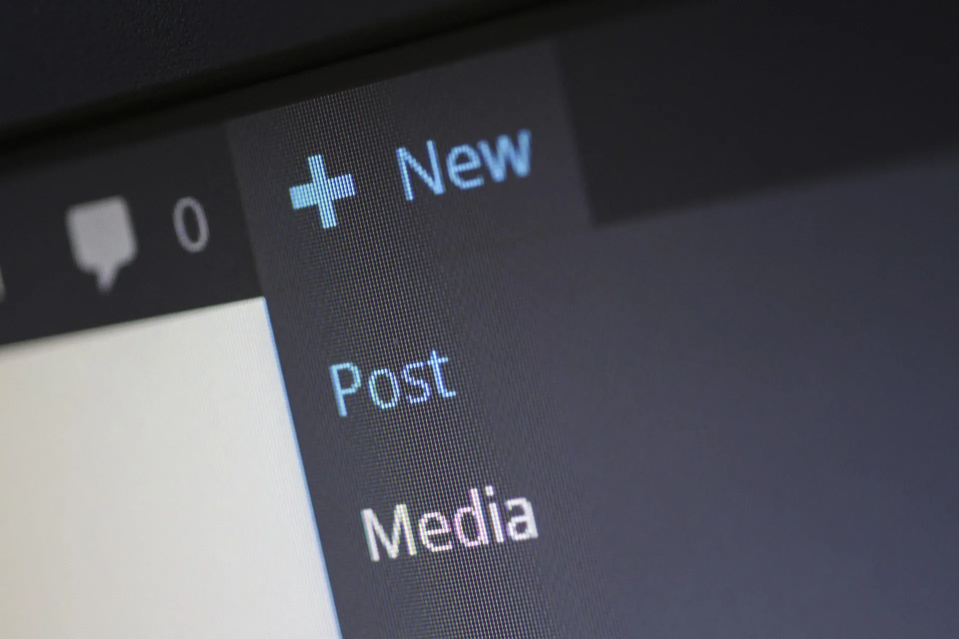 Close up view of a screen with a 'new' button and a dropdown menu with 'post' and 'media' options