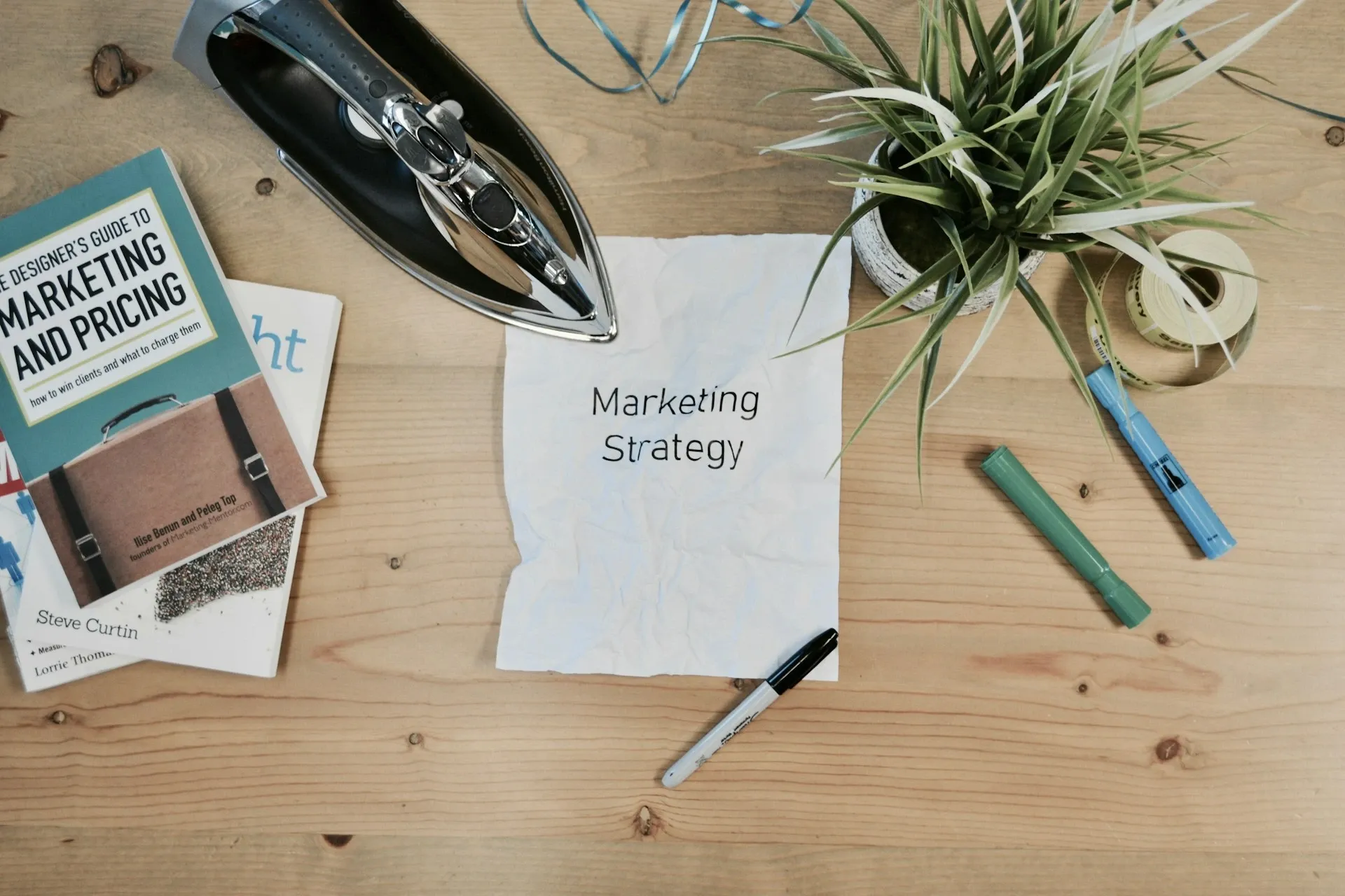 A crumpled white paper with Marketing Strategy text being ironed out